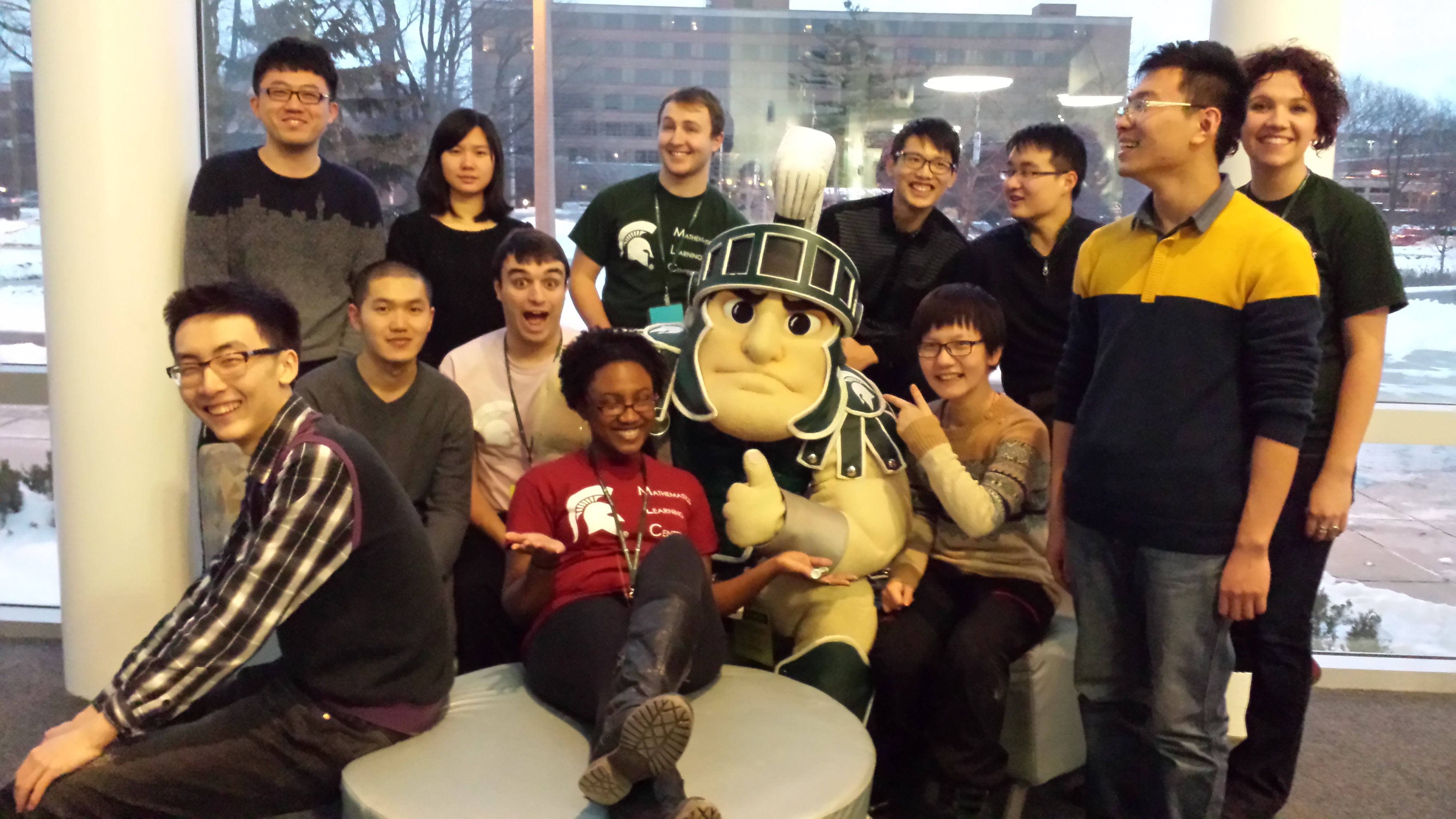 Students posing for photo around the Sparty mascot