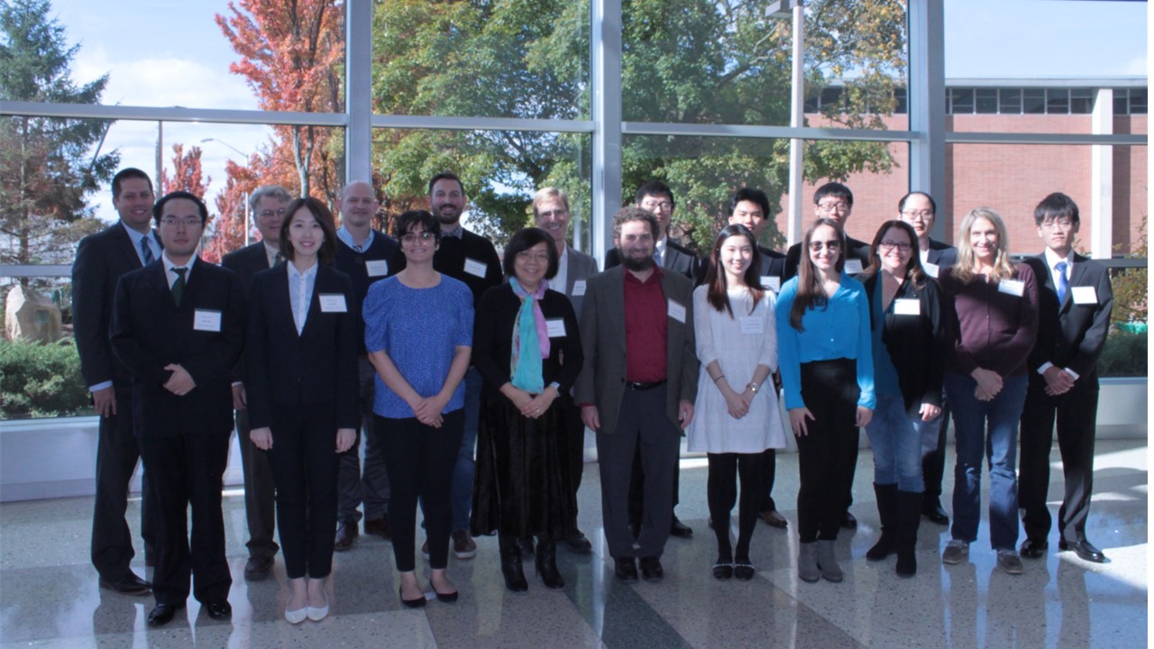 A group photo featuring MSIM students, Peiru Wu, Jeffrey Schenker and others standing in front of a large window.